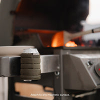 Luno Magnetic Can Cooler attached to metal grill surface while camping